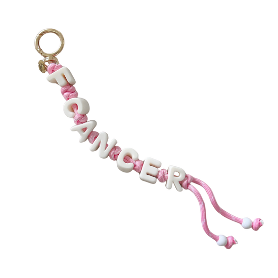 Pink and white 'F CANCER' charm on a white background