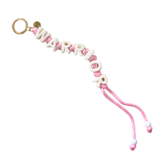 Pink keychain with 'WARRIOR' letters on a white background