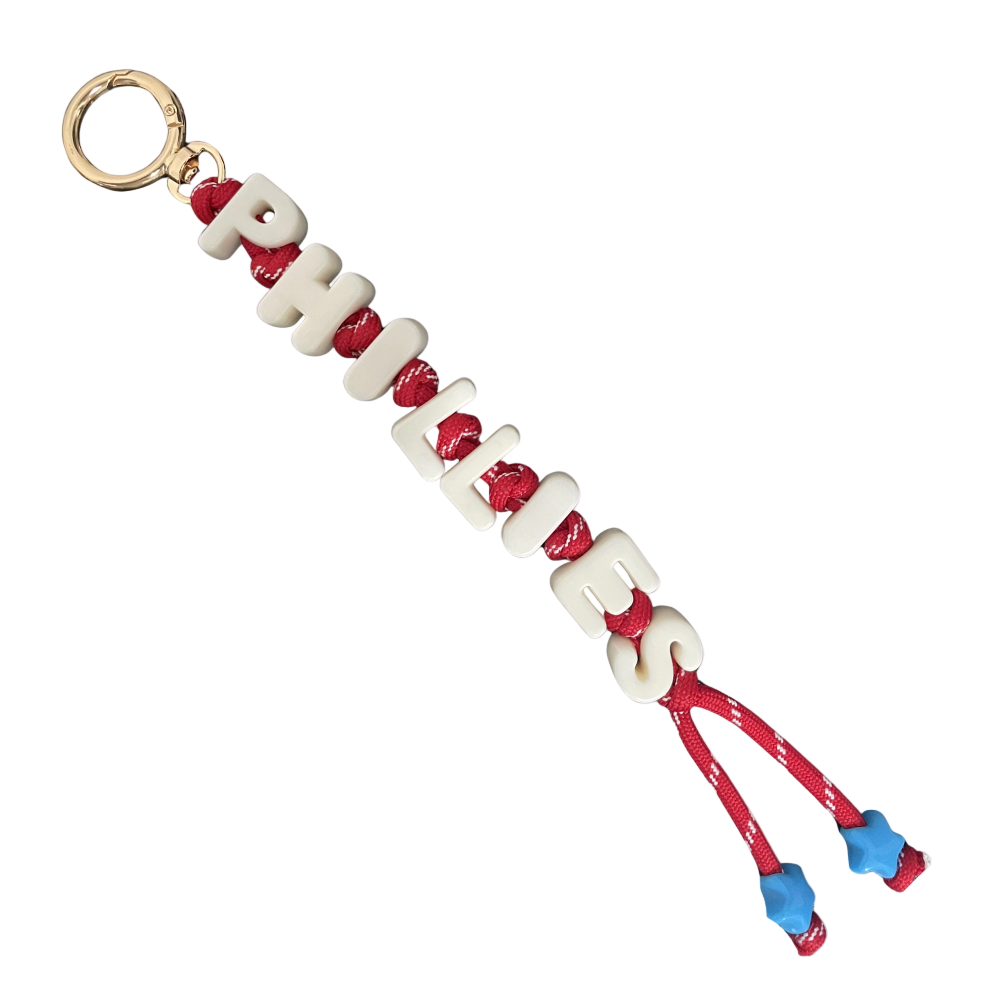 Keychain with red and blue accents on a light pink background