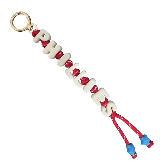 Keychain with red and blue accents on a light pink background