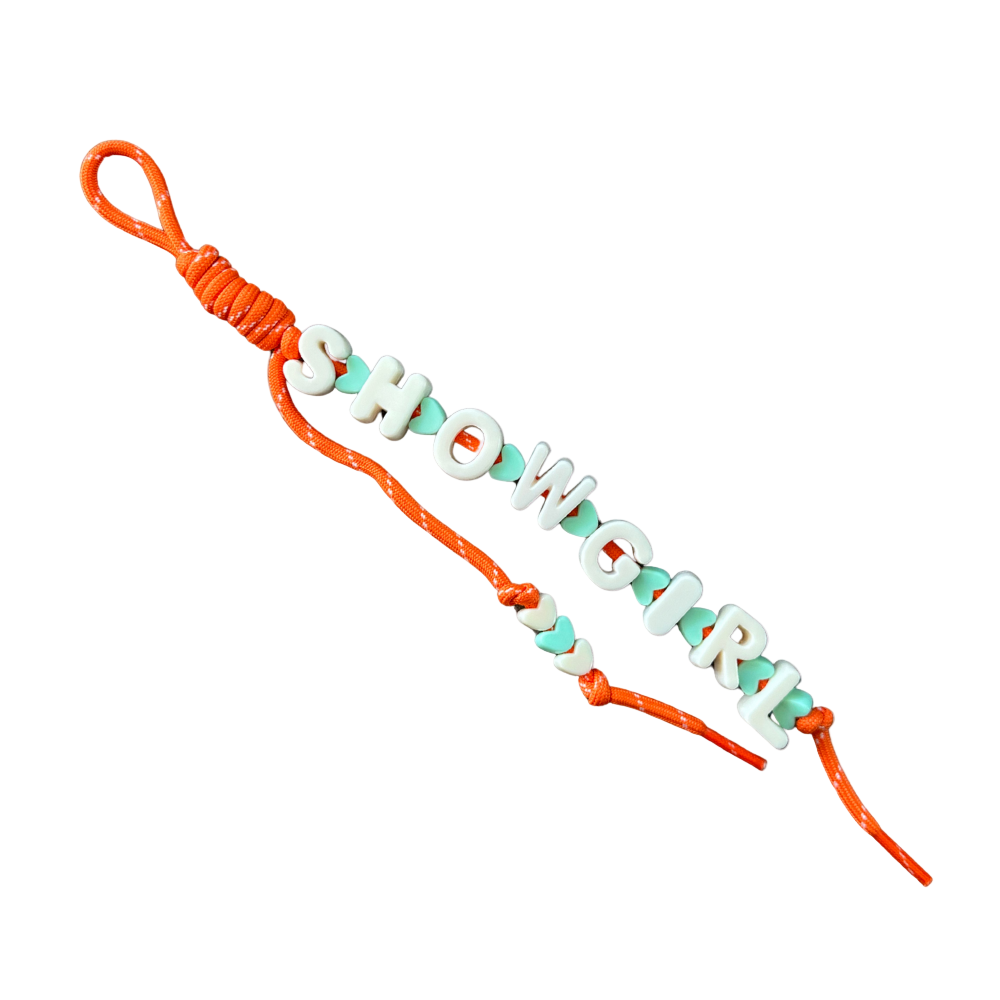 Bracelet with orange cord and green beads spelling 'SHOWGIRL' on a white background