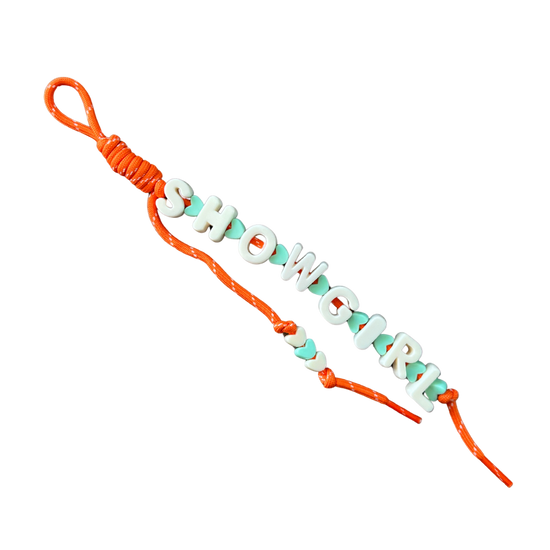 Bracelet with orange cord and green beads spelling 'SHOWGIRL' on a white background