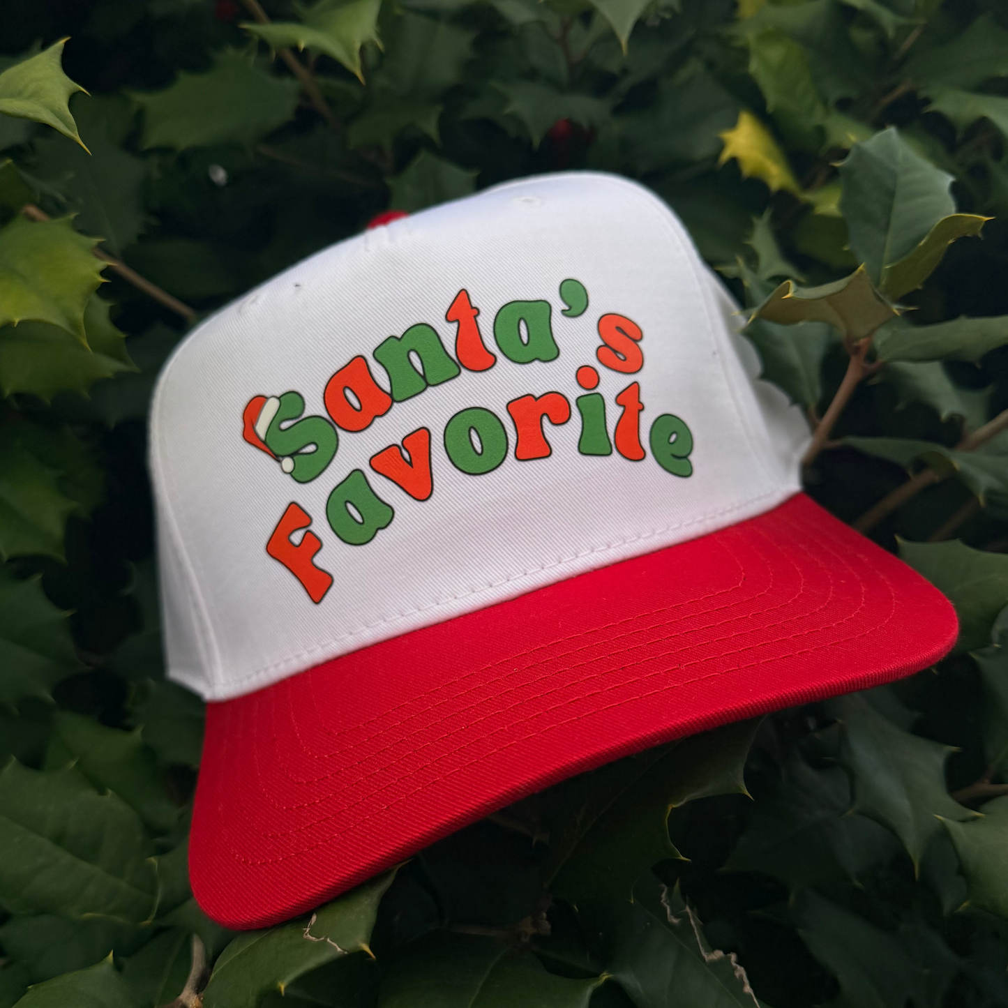 Trucker hat with 'Santa's Favorite' text on a green leafy background