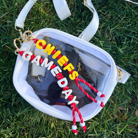 Clear bag with 'Chiefs Game Day' keychain on grass